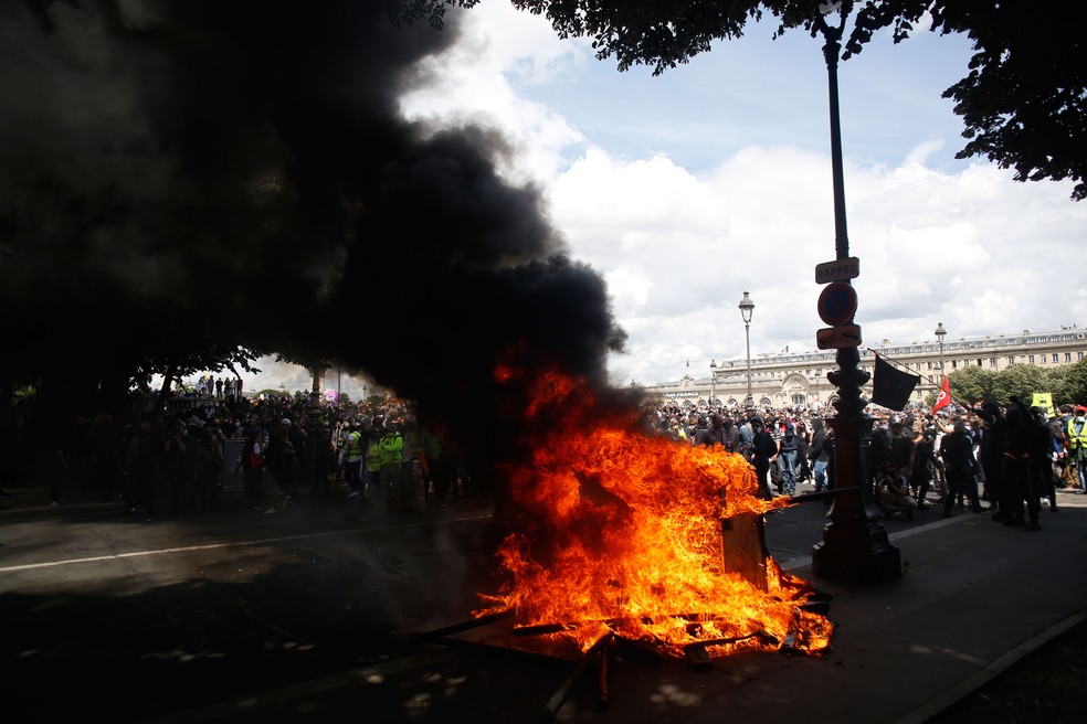Jovens colocam fogo durante um protesto de profissionais da saúde nesta terça-feira (16) em Paris   — Foto: Thibault Camus/AP