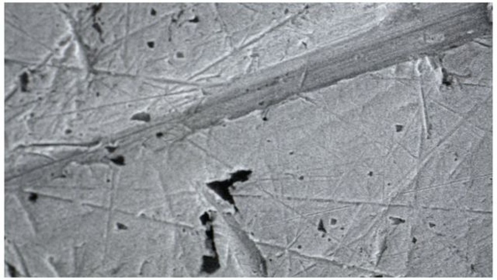Sob um poderoso microscópio, os pesquisadores identificaram marcas de arranhões causadas pela circulação das moedas — Foto: BBC NEWS