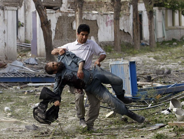 Policial afegão ferido é carregado do local de uma explosão em Cabul nesta sexta-feira (24) (Foto: Omar Sobhani/Reuters) Policial afegão ferido é carregado do local de uma explosão em Cabul nesta sexta-feira (24) (Foto: Omar Sobhani/Reuters)