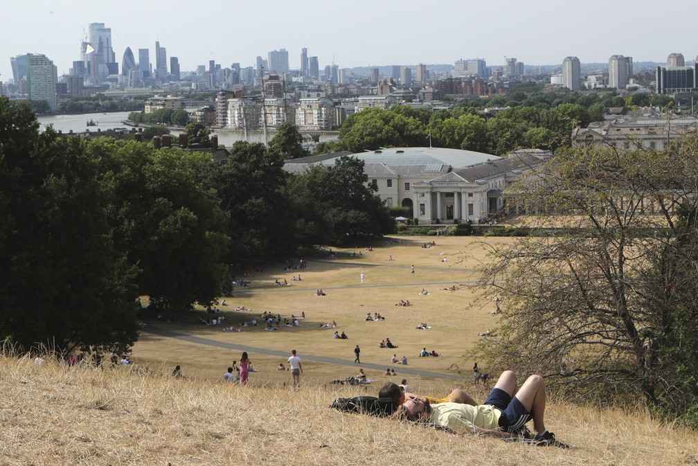 Britânicos aproveitam o sol no Greenwich Park, um dos maiores parques de Londres. Reino Unido emitiu um "alerta vermelho" de calor extremo para esta segunda (18) e terça-feira (19), quando as temperaturas no sul da Inglaterra podem chegar pela primeira vez a 40°C. — Foto: AP Photo/Tony Hicks