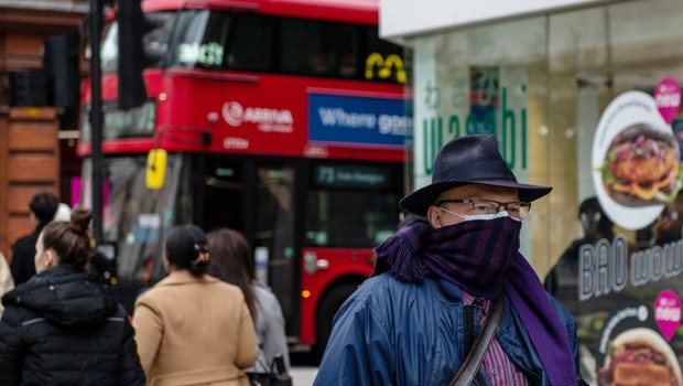 Homem caminha de máscara facial e cachecol na Oxford Street em meio ao surto de coronavírus em Londres, Inglaterra (Foto: Getty Images)