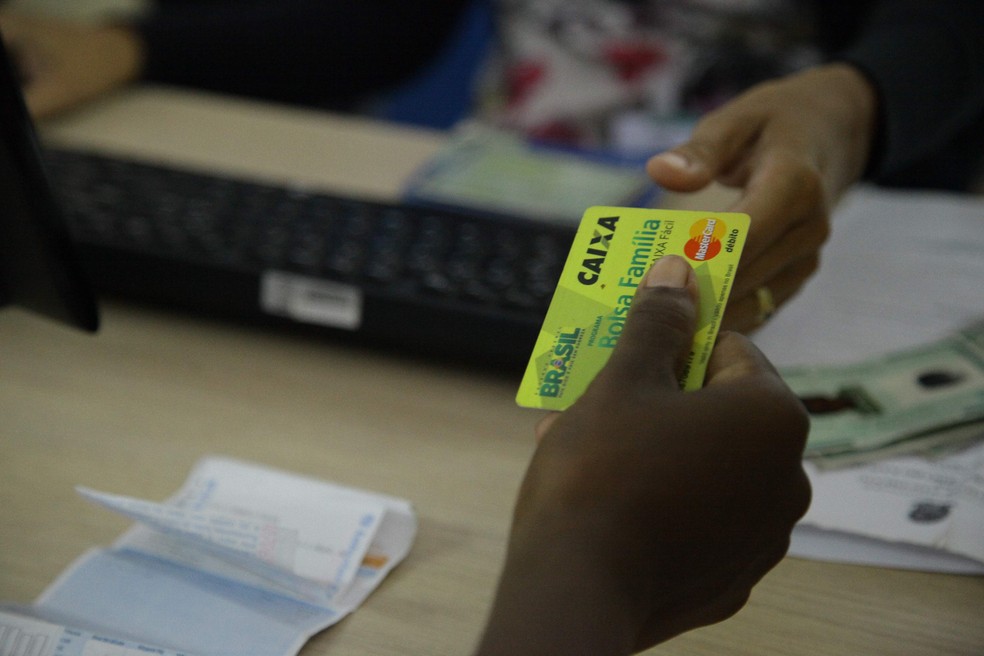 Beneficiário entrega cartão do Bolsa Família para recebe dinheiro — Foto: Flora Dolores/O Estado/Arquivo
