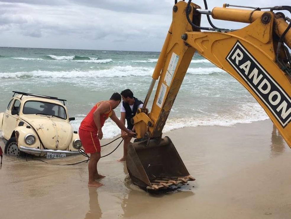 Uma retroescavadeira foi usada pela prefeitura para tirar carro do mar (Foto: Prefeitura de Florianópolis/divulgação)