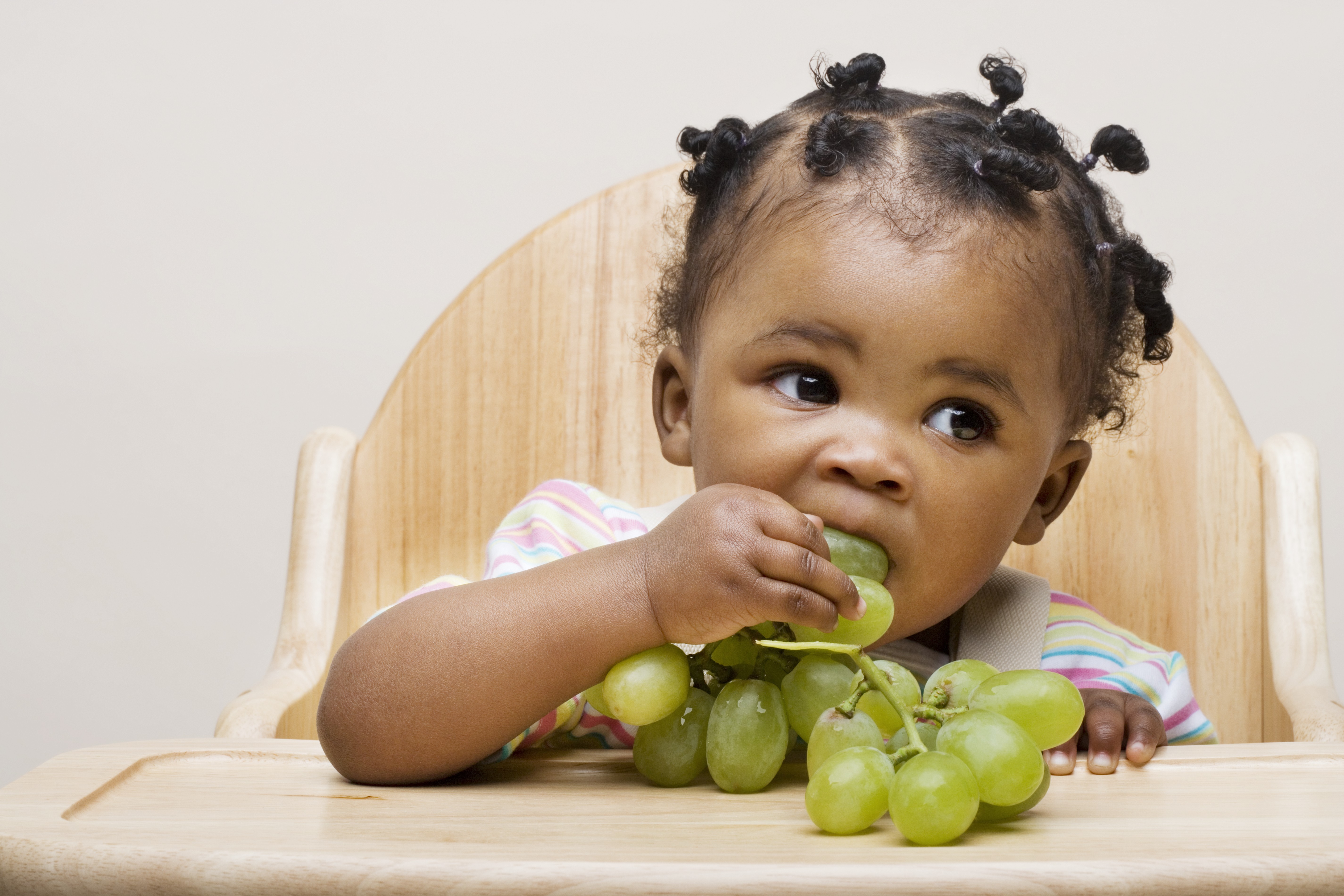 Criança comendo fruta, uva (Foto: Image Source/Getty Images)