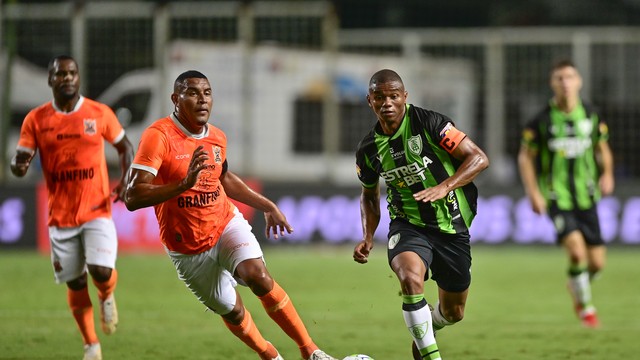 Juninho, do América-MG, tenta escapar da marcação do Nova Iguaçu