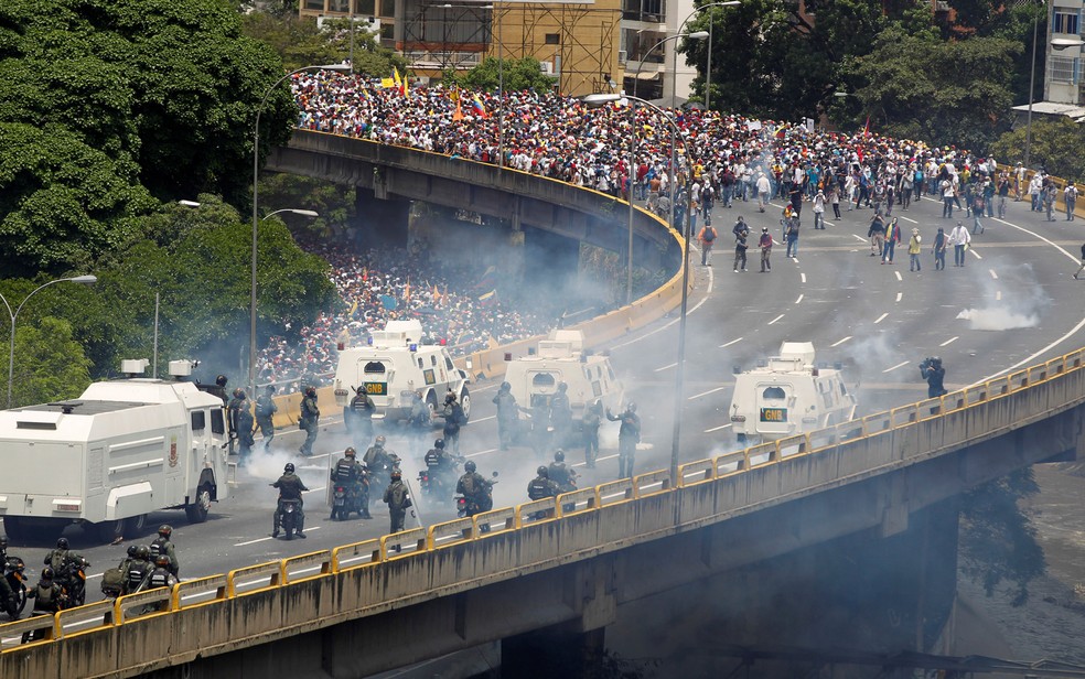 Polícia de choque age contra manifestantes em Caracas na quarta-feira (19) (Foto: Christian Veron/Reuters)