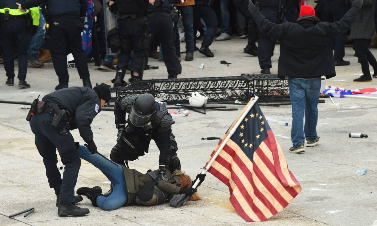 A polícia detém um manifestante durante protesto pró-Trump em frente ao Congresso americano — Foto: ROBERTO SCHMIDT / AFP