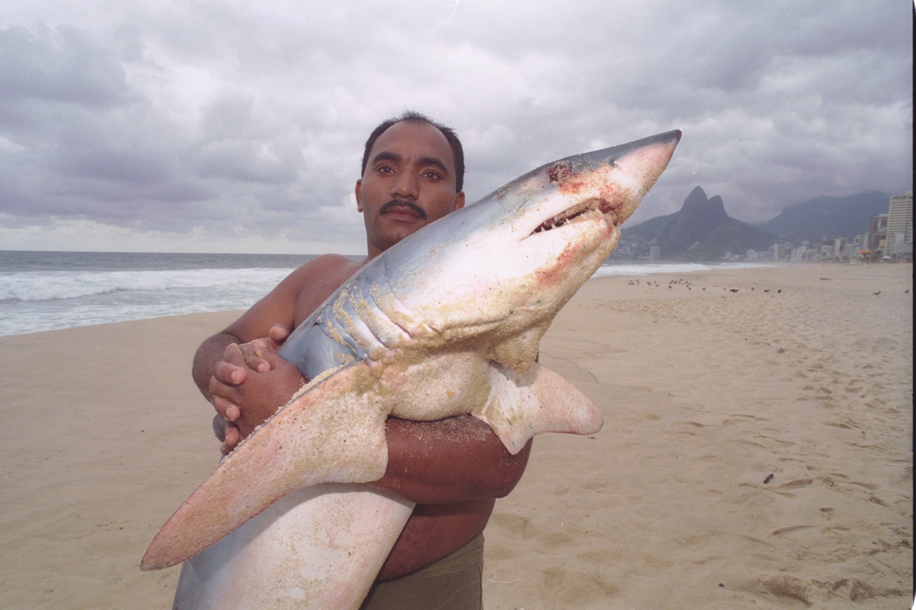 O porteiro José Nilson com o tubarão capturado em Ipanema, em julho de 1999