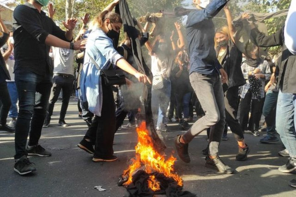 Mulheres agitam seus véus no ar e ateiam fogo durante protestos — Foto: Getty Images via BBC