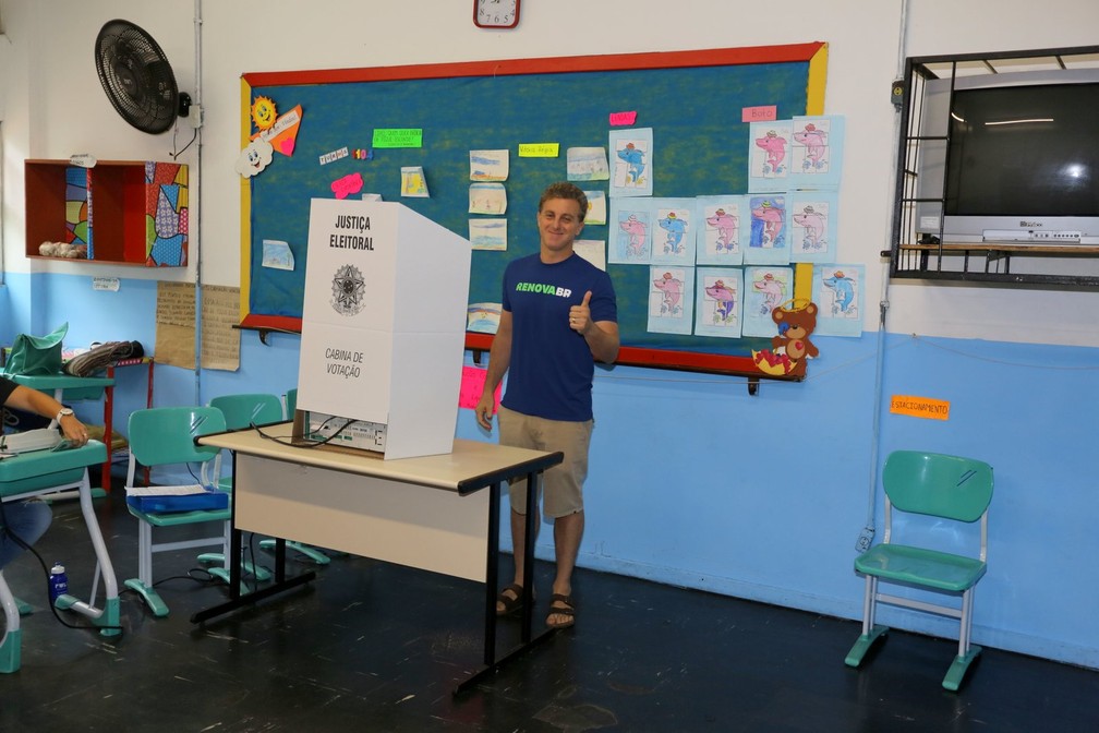 Luciano Huck vota no Rio de Janeiro. O Apresentador foi ao local acompanhado de um de seus filhos e fez selfie com ele no corredor da escola — Foto: AgNews