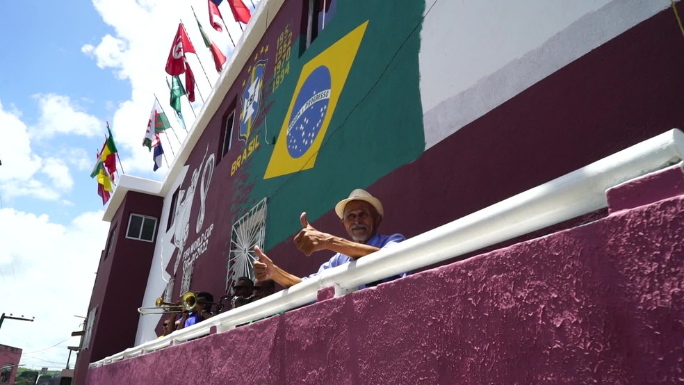 Luiz Paulino, de 81 anos, em frente à casa decorada para a Copa do Mundo de 2022 — Foto: Reprodução/TV Globo