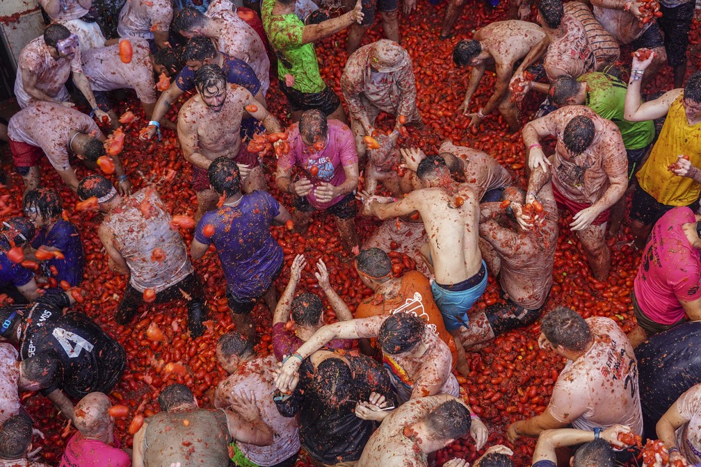 Participantes jogam tomates uns nos outros durante o festival "Tomatina" em Buñol, na Espanha, em 31 de agosto de 2022 — Foto: Alberto Saiz/AP