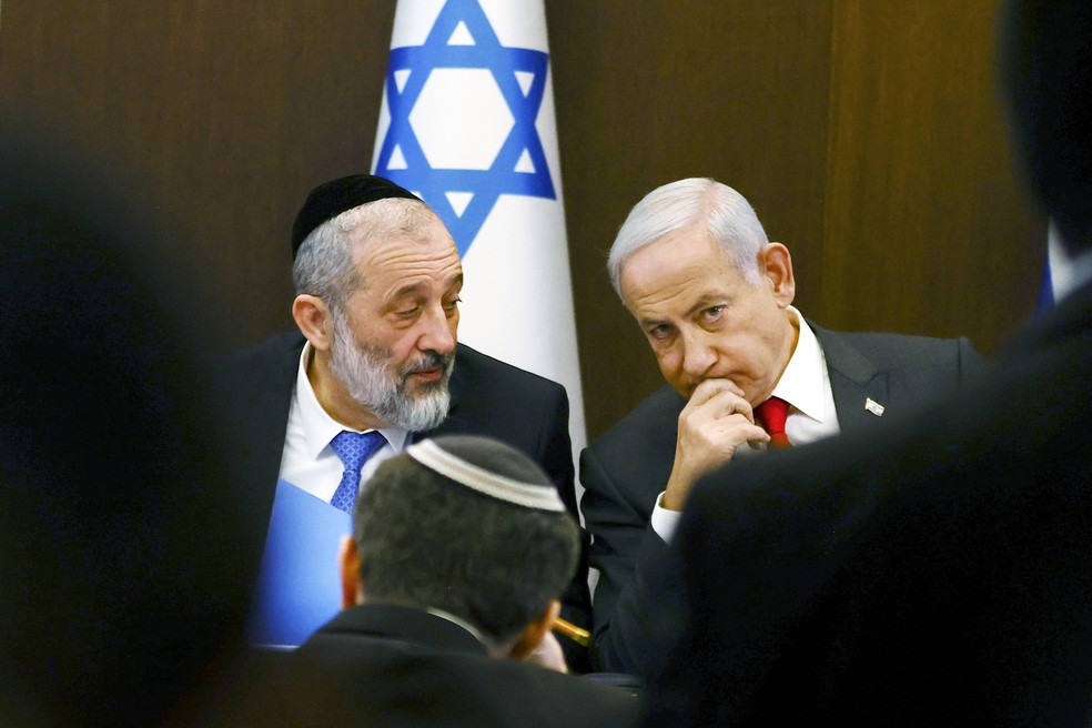 Primeiro-ministro de Israel, Benjamin Netanyahu (dir.) ao lado do ministro Aryeh Deri em reunião do gabinete — Foto: Ronen Zvulun/Pool Photo via AP