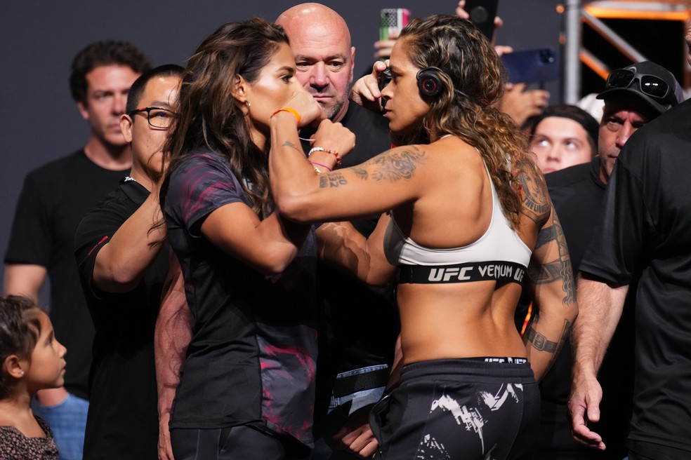 Julianna Peña (esq.) e Amanda Nunes (dir.) se encaram intensamente na pesagem cerimonial do UFC 277 — Foto: Josh Hedges/Zuffa LLC