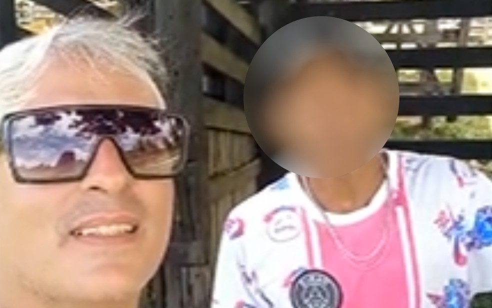 Médico que filmou homem negro preso com correntes e algema grava novo vídeo ao lado dele, em cidade de Goiás — Foto: Reprodução/TV Anhanguera