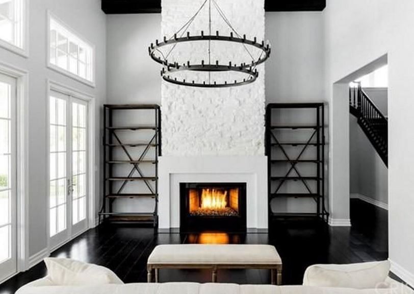 Sala de estar segue décor sofisticado e minimalista, com tijolos a vista pintados de branco (Foto: Reprodução)