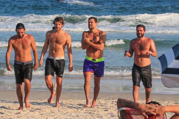 Felipe Roque (de bermuda roxa) curte praia com amigos (Foto: Fabricio Pioyani/AgNews)