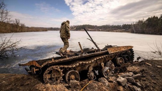 um-soldado-ucraniano-fica-perto-de-um-tanque-russo-destruido-marco-de-2022.jpg