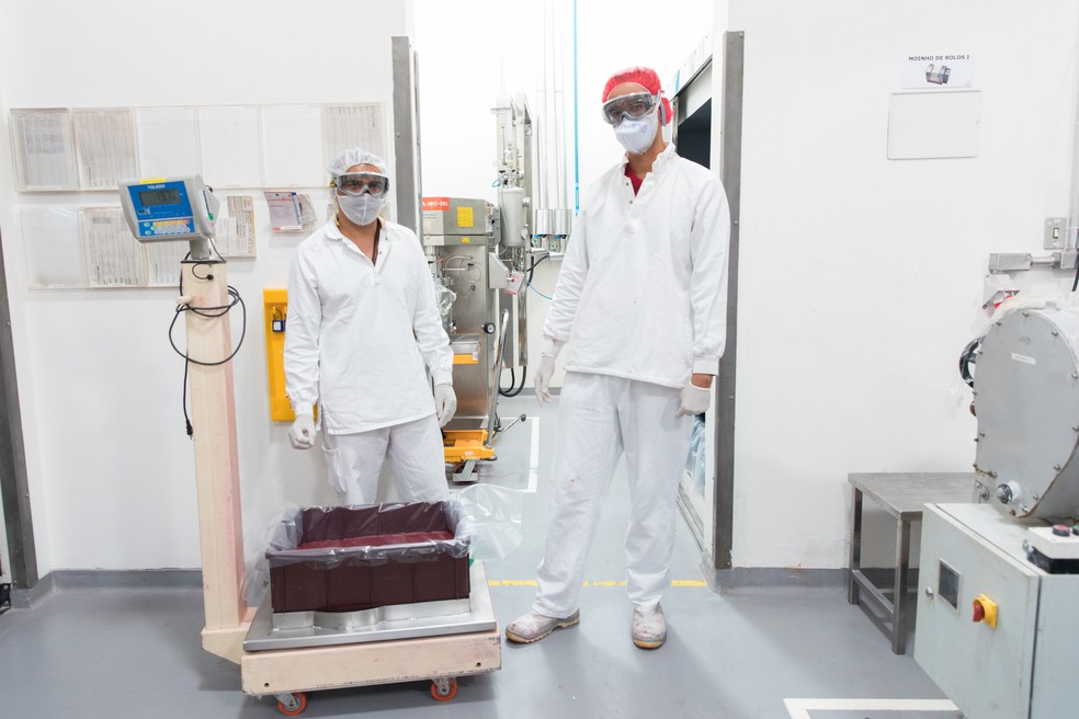 Funcionários encaminham a mistura para a armazenagem, onde o produto permanece até ficar sólido (Foto: Celso Tavares/G1)