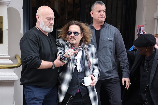 O ator Johnny Depp deixando um hotel na cidade inglesa de Birmingham na companhia de seguranças (Foto: Getty Images)