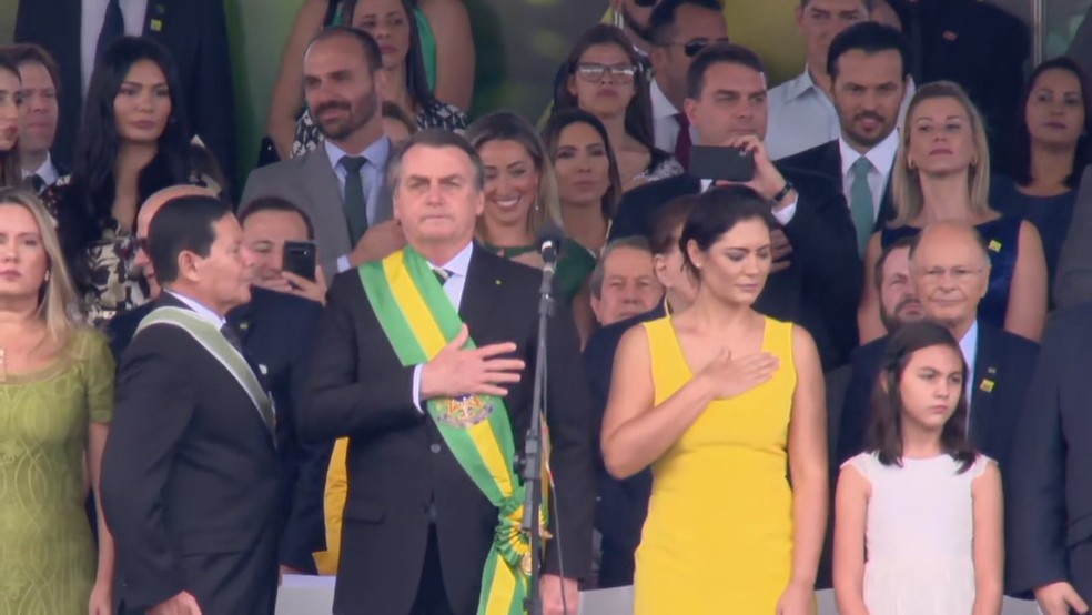 O presidente Jair Bolsonaro durante o desfile de 7 de setembro, em Brasília, ao lado do vice-presidente, Hamilton Mourão, e da primeira-dama, Michele Bolsonaro — Foto: TV Globo/Reprodução