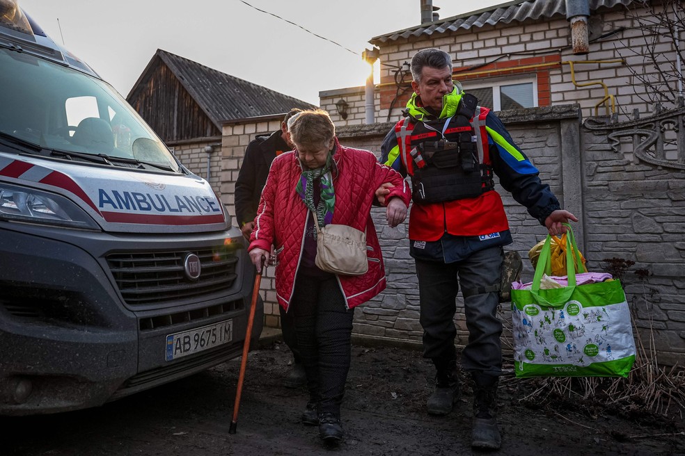 Voluntário da Cruz Vermelha auxilia na retirada de moradores em área atingida por bombardeios em Kupiansk, região de Kharkiv — Foto: ANATOLII STEPANOV / AFP