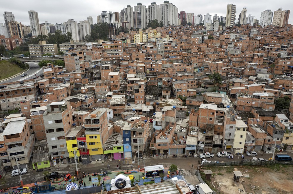 Trabalhadores pintam as fachadas das residências na favela de Paraisópolis, como parte da celebração do centenário da comunidade, em 16 de setembro de 2021, em São Paulo — Foto: Andre Penner/AP