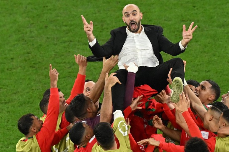 Técnico Walid Regragui nos braços dos jogadores de Marrocos após eliminar a Espanha, nas oitavas de final