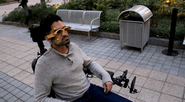 Pessoa usa os óculos da MagTrack em cadeira de rodas motorizada (Foto: Divulgação)