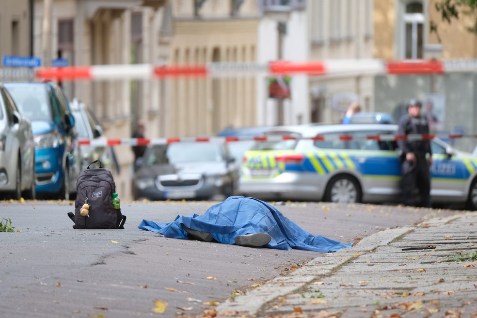 Um corpo caído na rua é coberto em uma área bloqueada pela polícia após ataque em Halle an der Saale, no leste da Alemanha, em outubro de 2019 — Foto: Sebastian Willnow/dpa/AFP