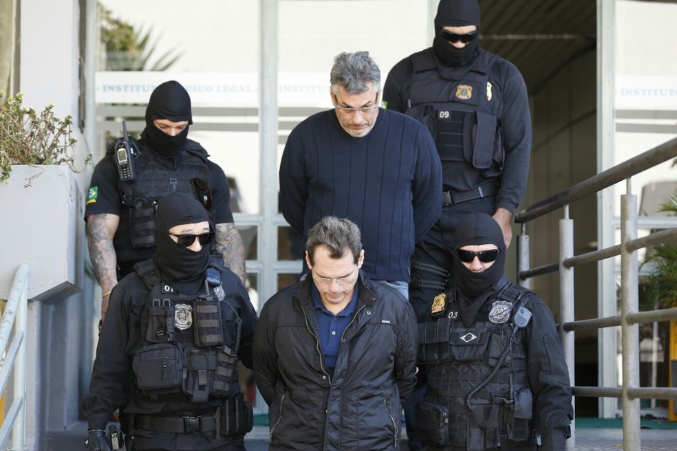 Ant&ocirc;nio Carlos (abaixo) &eacute; escoltado por policiais federais, junto com o irm&atilde;o, Andr&eacute; Gustavo, no dia em que fizeram os exames de delito no IML de Curitiba (Foto: Rodrigo Fonseca )