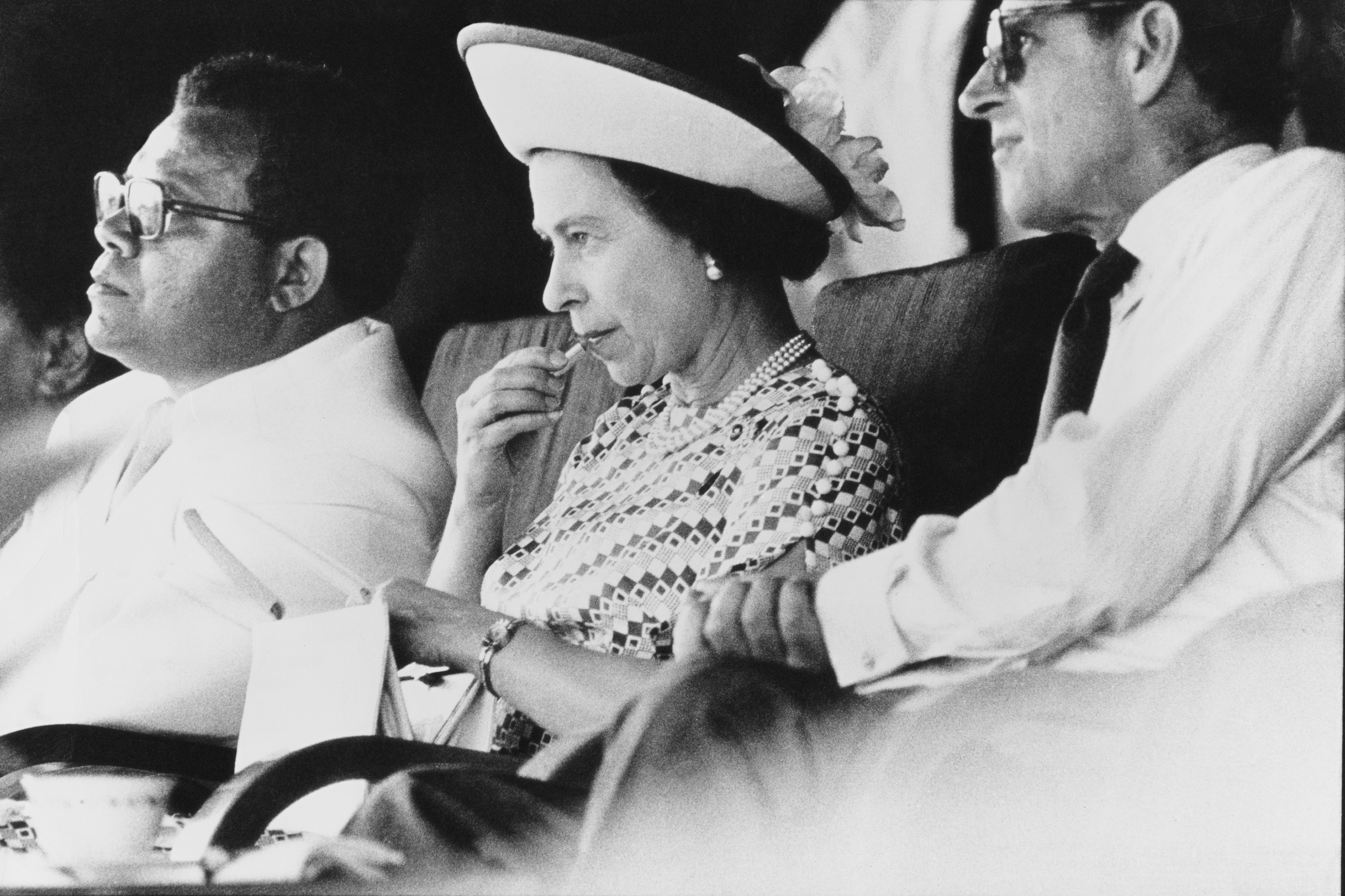 Queen Elizabeth II applies her lipstick at a function during a visit to Fiji with Prince Philip (right), February 1977. (Photo by Tim Graham/Hulton Archive/Getty Images) (Foto: Tim Graham/Getty Images)