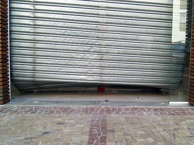 Loja no bairro Cambuí, em Campinas, com a porta danificada pela gangue da marcha à ré (Foto: Marcello Carvalho/G1)
