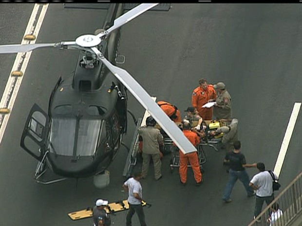 Vítima, na maca, é colocada em helicóptero para ser levada a hospital (Foto: Reprodução / TV Globo)