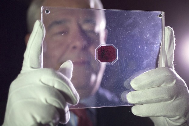 LONDON, ENGLAND - JUNE 02:  An employee of Sotheby's auction house holds a case containing the sole-surviving 'British Guiana One-Cent Magenta' stamp dating from 1856, on June 2, 2014 in London, England. The unique stamp is expected to fetch 20 million US (Foto: Getty Images)