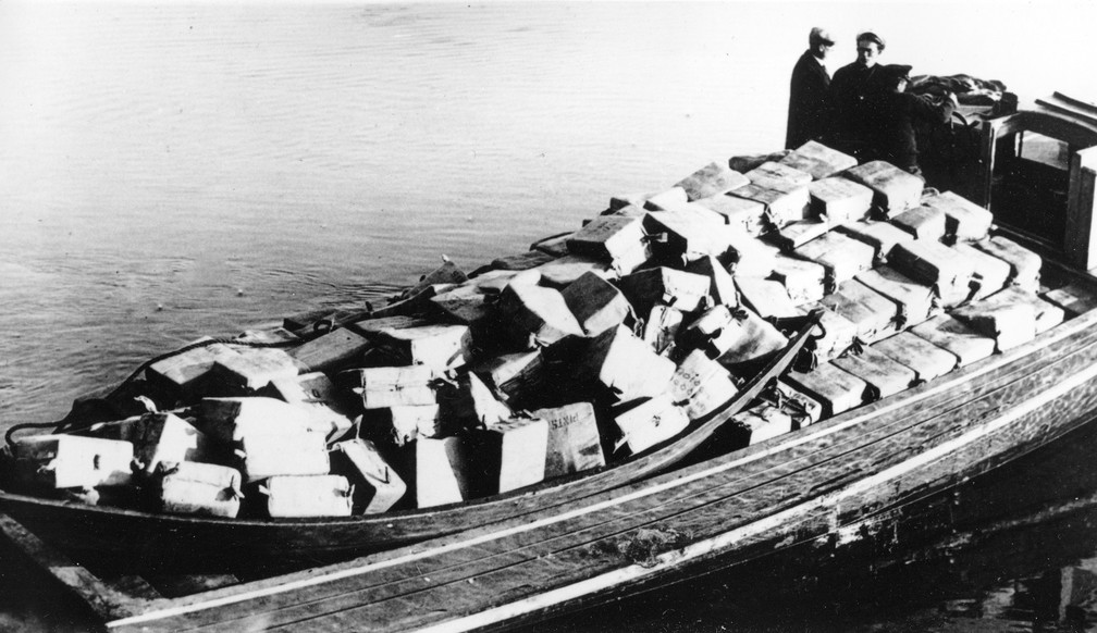 Guardas são vistos em barco contendo quase 700 caixas de bebida alcoólica apreendida ao ser descarregada em Newburyport, Massassuchetts, em 6 de maio de 1932 — Foto: AP Photo, File