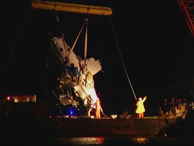 Destroços do avião são colocados na balsa após serem içados em Paraty na noite deste domingo (22) (Foto: Reprodução / TV Globo)