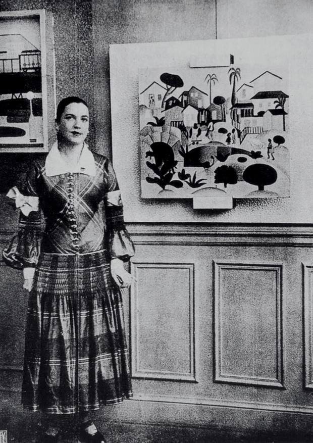 Com um vestido de Paul Poiret ao lado de Morro de Favela, na inauguração de sua primeira exposição individual em Paris, em 1926 (Foto: Fotos e imagens das obras: acervo pessoal)