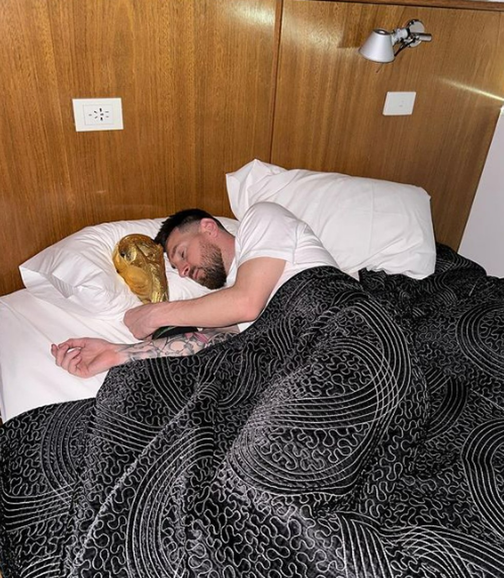 Messi deitado ao lado da taça da Copa do Mundo — Foto: Reprodução/Instagram