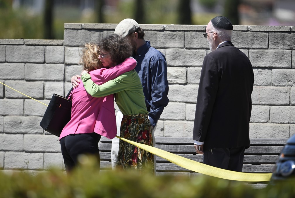 Membros de comunidade judaica na Califórnia se abraçam perto da sinagoga onde homem abriu fogo neste sábado (27). Uma pessoa morreu — Foto: Denis Poroy/AP Photo