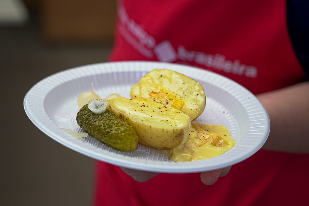 Raclette: queijo suíço derretido servido sobre batatas cozidas, pepinos e cebolas-pérola — Foto: Rafael Leal/g1