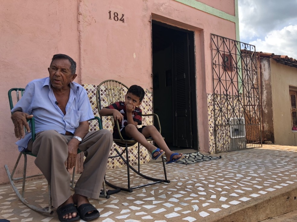 Seu Henrique, ao lado de um dos 28 netos,  é um dos moradores mais velhos de Flamengo — Foto: Rafael Honório