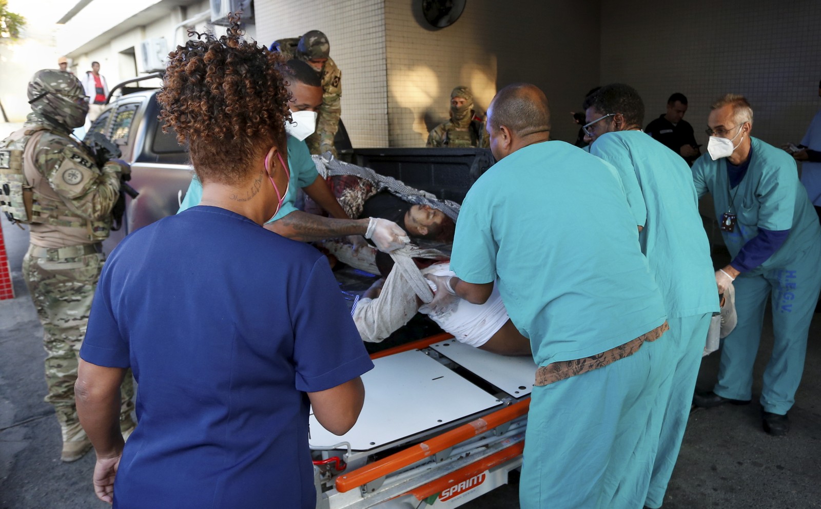 Feridos chegam levados na caçamba de viatura da PM ao Hospital Getúlio Vargas, na Penha.  — Foto: Fabiano Rocha/Agência O Globo