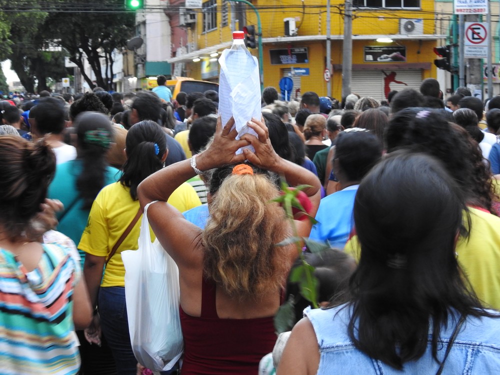 Devota carrega garrafa de água em romaria (Foto: Ive Rylo/ G1 AM)