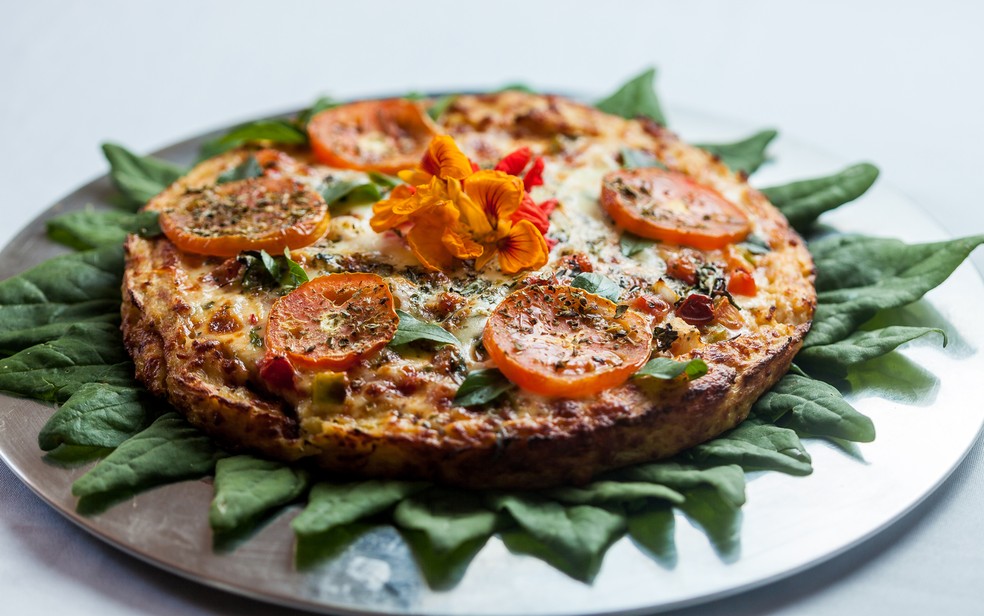 Pizza com massa de couve-flor coberta de muçarela, tomate e manjericão — Foto: Restaurante Família Daniel/Divulgação