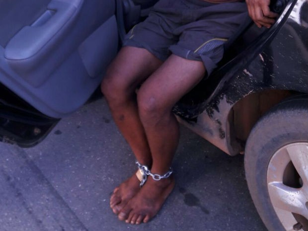 Jovem foi acorrentado por ser o suspeito de roubar uma loja (Foto: Divulgação/PM)