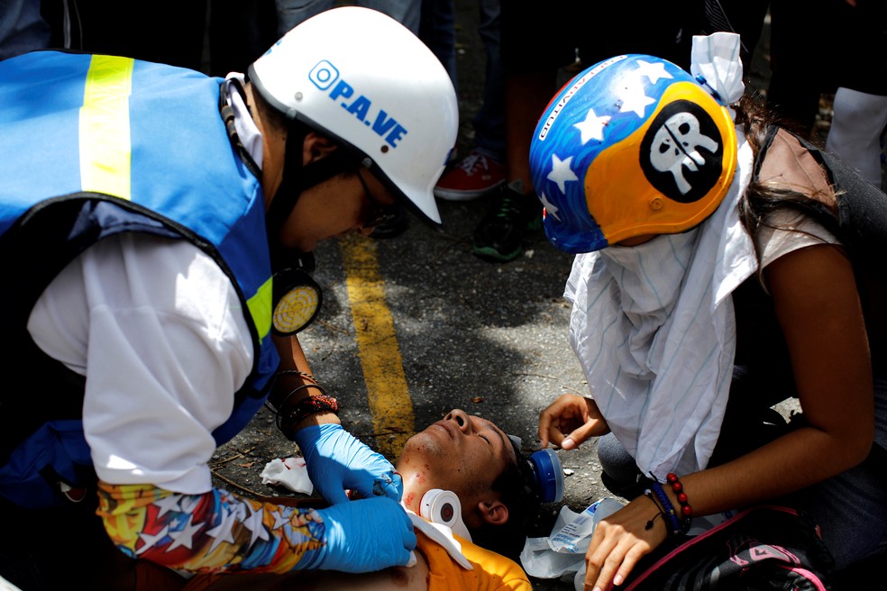 Homem ferido em Caracas é atendido durante manifestação contra o presidente Nicolás Maduro (Foto: REUTERS/Carlos Garcia Rawlins)