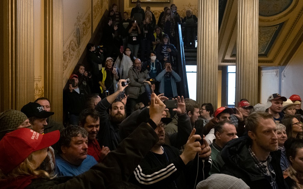 Manifestantes entram em prédio do Congresso de Michigan, nos EUA, nesta quinta-feira (30) — Foto: Seth Herald/Reuters