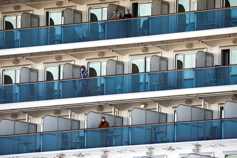 Passageiros de navio em quarentena atracado em Yokohama, no Japão, permanecem nas varandas das cabines nesta terça-feira (19) — Foto: Athit Perawongmetha/Reuters