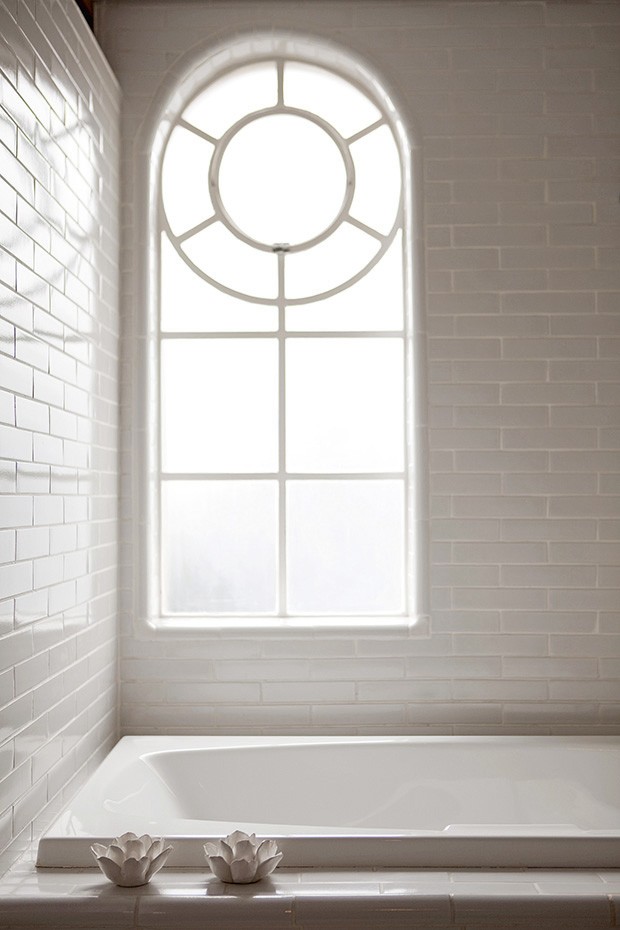A janela de desenho mais clássico, inerente ao estilo do prédio, integra-se ao visual do banheiro, que tem paredes revestidas de cerâmica branca: simples e chique (Foto: Marco Antonio / Casa & Jardim)
